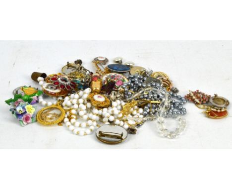 A quantity of costume jewellery including cameo brooches, enamel brooches, beaded necklaces, etc, contained within a beaded b