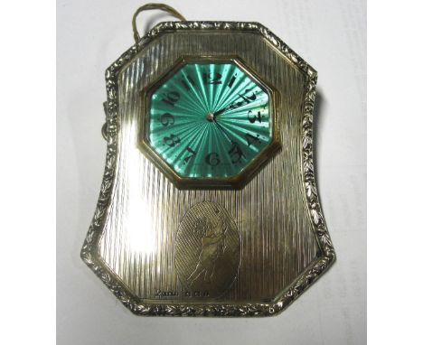 A George V hallmarked silver framed clock, the shaped frame edged by a foliate wreath and decorated with an engraved cherub i