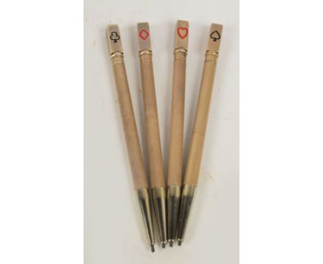 A cased set of four sterling silver propelling pencils with engine turned decoration and card symbols to the finials, length 