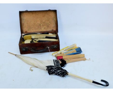 A group of ebony dressing table items to include two hand brushes, a hand mirror, three pairs of glove stretchers, and a grou