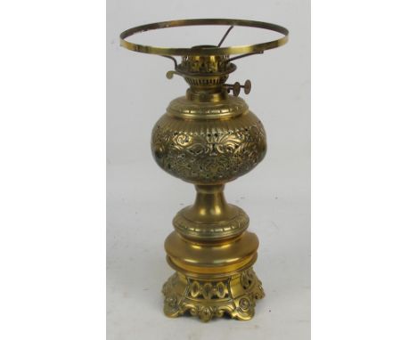 A Victorian brass oil lamp with pierced decorative reservoir, converted to electricity (lacking shade), height 42cm.