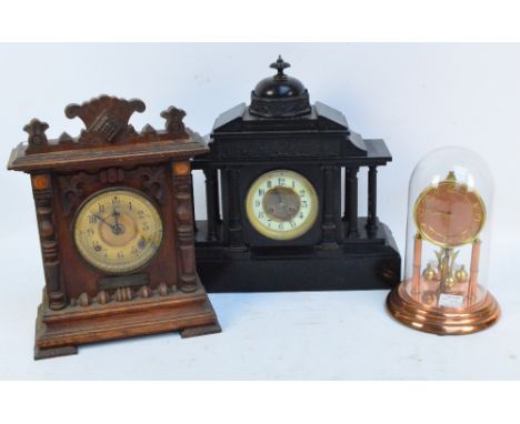 A late 19th century slate mansion mantel clock with column and pilaster supports and figural frieze beneath a dome and finial