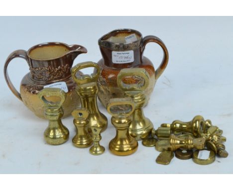 A collection of brass weights including two sets of bell weights and various flat circular weights, also two stoneware huntin