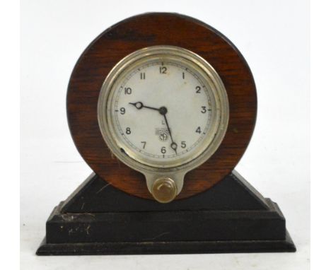 A Smith's car or aeroplane clock set with Arabic numerals, now mounted in an oak frame, width 19cm.