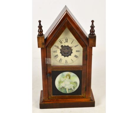 A late 19th century American "Gingerbread" clock with arched case and Roman numerals to the chapter ring, height 38cm.