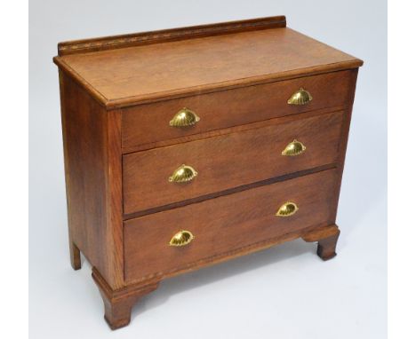 A small early 20th century light oak chest of three drawers raised on ogee bracket feet, width 93cm. CONDITION REPORT: Split 