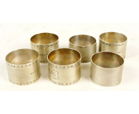 A set of four George VI hallmarked silver napkin rings with overall engine turned decoration and bright cut borders with rect
