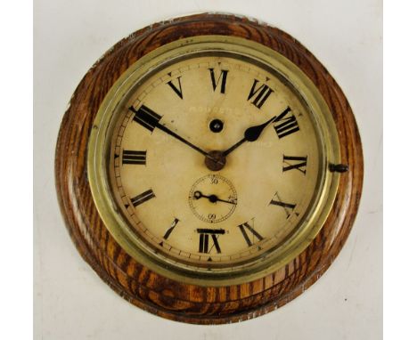 An early 20th century brass cased circular ship's clock with painted dial set with Roman numerals and indistinctly inscribed 