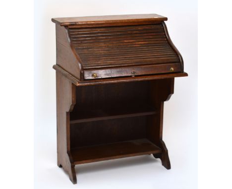 A small early 20th century roll top desk raised on shaped end supports and single shelf, width 77cm.