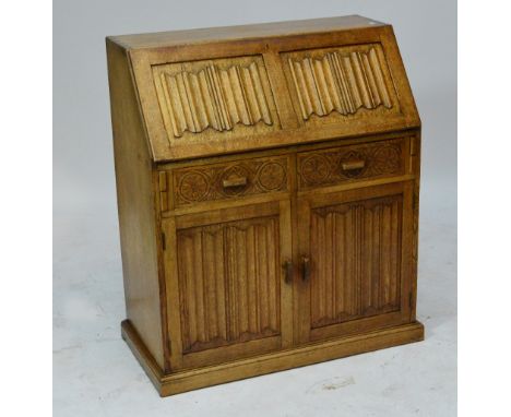 A light oak bureau, the linen fold carved fall front above two drawers and pair of doors, width 92cm.