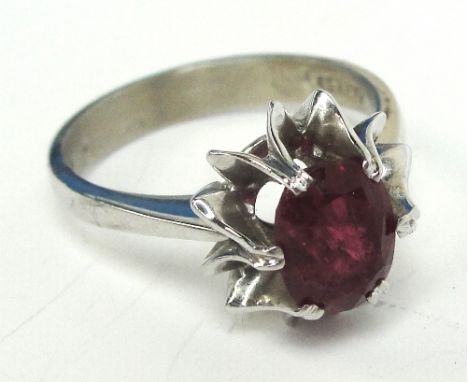 A 14ct white gold and ruby ring, the oval cut stone in high claw setting, size L, approx 4.2g.