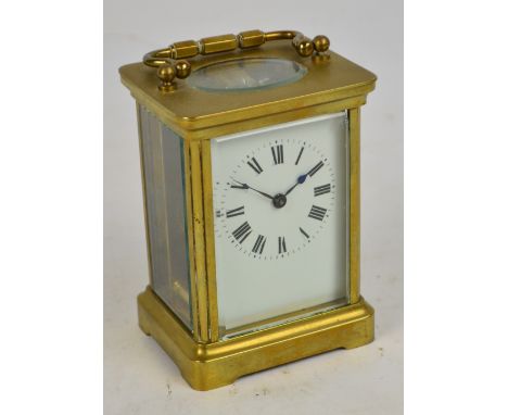 A c.1900 French brass cased carriage clock with swing loop handle, rectangular white enamel dial set with Roman numerals and 