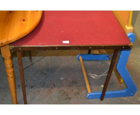 A mahogany folding card table with brass corners and red felt