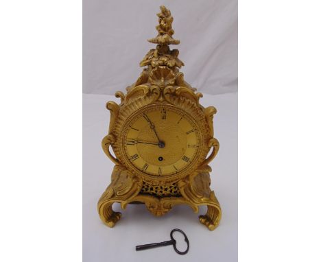 A gilded metal mantle clock, the engine turned circular dial with Roman numerals within a Rococo style case, A/F, 32cm (h)
