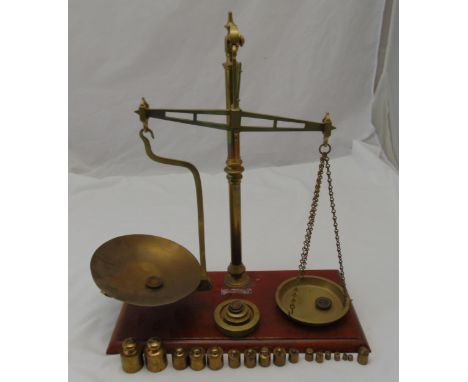 A brass balance scale on rectangular mahogany stand with weights