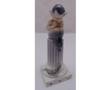 Royal Copenhagen figurine of a fawn playing a pipe perched on a column with applied lizard on raised square base, marks to th
