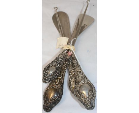 Two Edwardian shoe horns and two button hooks, each with embossed silver handles. C.R. All good