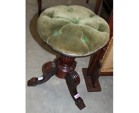A Victorian rosewood piano stool with screw rising button upholstered top and tripod outswept support