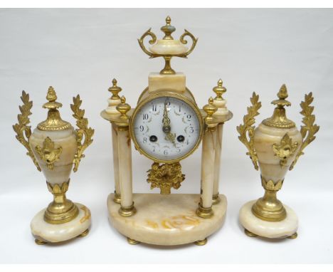 A French Empire style three piece alabaster and gilt metal clock garniture, the clock in a drum shaped case and having a whit