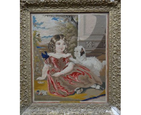 A nineteenth century pictorial tapestry of a reclining girl and puppy, in a decorative gilt gesso and wood frame, 23ins x 20.
