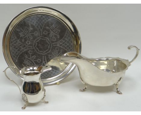 A silver sauce boat of plain form, similar cream jug and a circular silver tray, and a matching silver spoon and fork, 18ozs