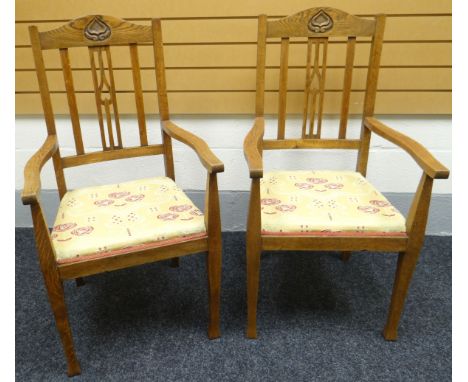 A pair of early-twentieth century Arts & Crafts style joined oak chairs with cushion seats