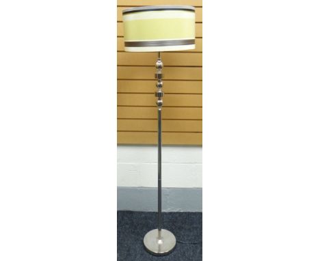 A contemporary chrome standard lamp on a circular base