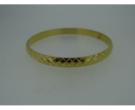 YELLOW METAL LADIES BANGLE OF CRISS-CROSS DESIGN (tested as high carat approximately 22ct gold), 43.1 grams