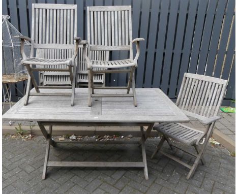 A contemporary faded and slatted teak garden patio suite comprising; X-frame rectangular table, length 165cm, and a set of 6 