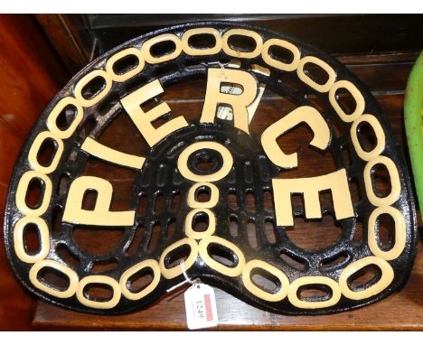 A pierced and cast iron tractor seat titled Pierce, painted in black and cream, 35 x 41cm