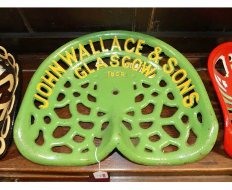 A pierced and cast iron tractor seat titled John Wallace &amp; Sons, Glasgow, 18CR, painted in green and yellow, 46 x 43.5cm