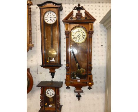 Two late 19th century walnut and ebonised Vienna drop trunk wall clocks, the larger with two weights and pendulum, the smalle