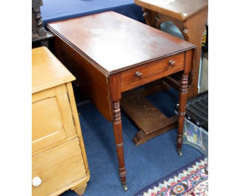 A Victorian mahogany Pembroke table on ring-turned legs fitted with a real and dummy drawers.