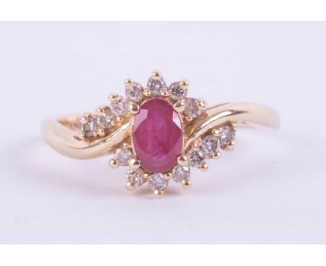 A 14ct modern ruby and diamond oval cluster ring, set in yellow gold, set with 14 round brilliant cut diamonds, the oval cut 