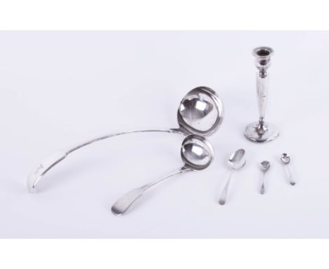 An Elkington and Co. silver-plated ladle and other plated spoons and a single candlestick.