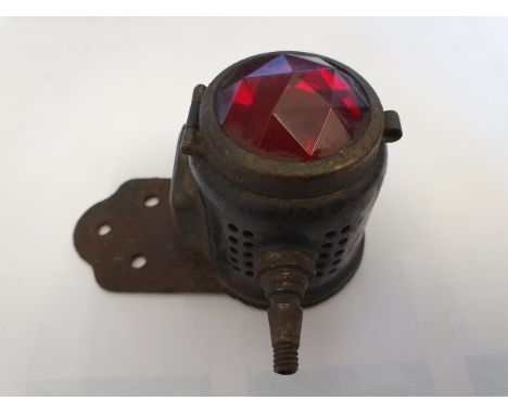 A Miller vintage motorcycle stop/number plate carbide lamp, with facetted red glass.