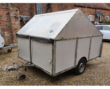 A coach-built motorcycle enclosed trailer, the hinged lid opening to reveal three-wheel holders, for either a pair of machine