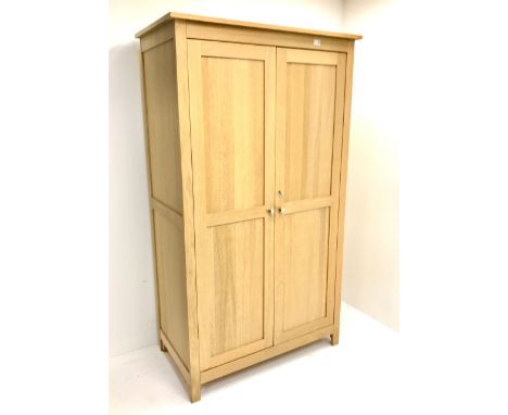 Light oak double wardrobe, projecting cornice, two doors enclosing fitted interior, stile supports Dimensions: Height:&nbsp;1