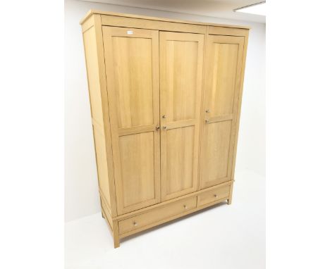 Light oak triple wardrobe, projecting cornice, three doors enclosing fitted interior above one long and one short drawer, sti