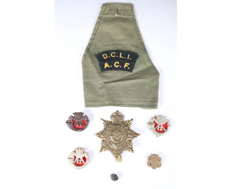 A collection of various Duke of Cornwall's Light Infantry badges and buttons, including a helmet badge, an ACF arm badge and 