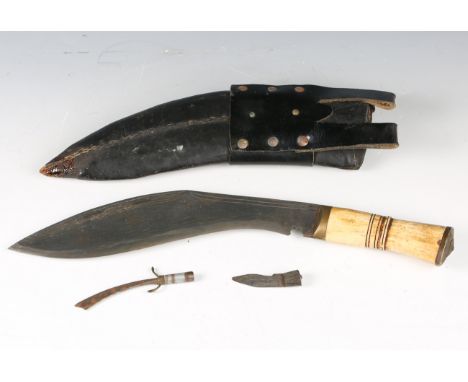 A mid-20th century kukri-style knife with engraved curved blade, blade length 24cm, and bone-handled grip, with leather scabb