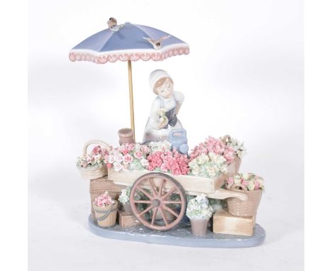 Lladro, 'Flowers of the Season' group, depicting girl attending a flower stall cart under an umbrella, width 29cm, height 28c