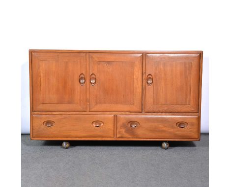 An Ercol sideboard, model 429, with three cupboard doors over two drawers, on ball castors, width 130cm, depth 45cm, height 7