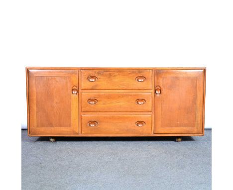 An Ercol dining room suite, comprising sideboard, (model 455), fixed top rounded rectangular table, and six Windsor Quaker ch