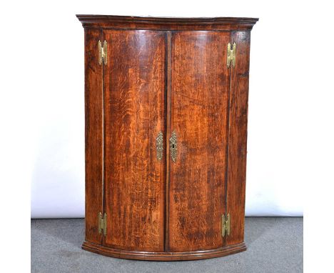 George III oak bowfront hanging corner cupboard, moulded cornice, three shelves, width 77cm, depth 53cm,  height 100cm.Condit