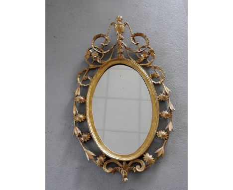 A George III carved gilt wood oval wall mirror, 18th century, the later plate within an incised frame and pierced open work f
