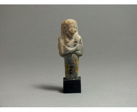 Egyptian ceramic New Kingdom, 1550 - 1077 BC; Shabti with mummiform body, arms crossed at chest, holding pick and hoe; wearin