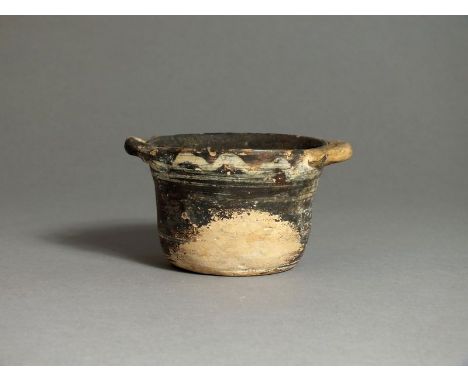 South Italian, Apulian, ceramic black glazed cup, 4th century BC; applied handles to rim, band to outer edge decorated wave p