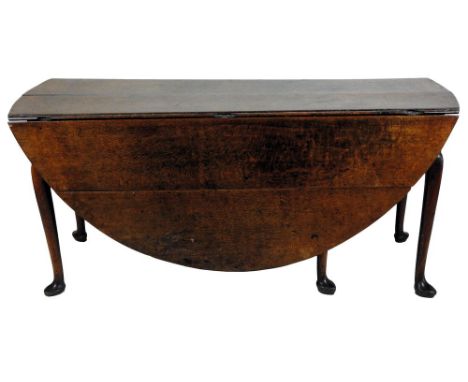 An oak single gate leg action drop leaf dining table, mid 18th century, the circular planked top raised on slender cabriole l