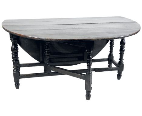 An oak gate leg table, 17th century, the oval planked top raised on baluster and block legs joined by grooved flat stretchers